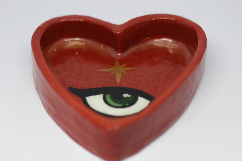 Coração vermelho fundo com olho verde e estrela dourada