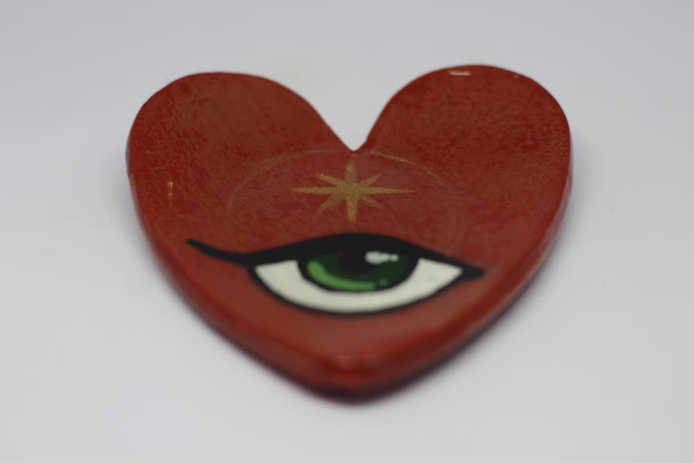 Coração vermelho com olho verde e estrela dourada
