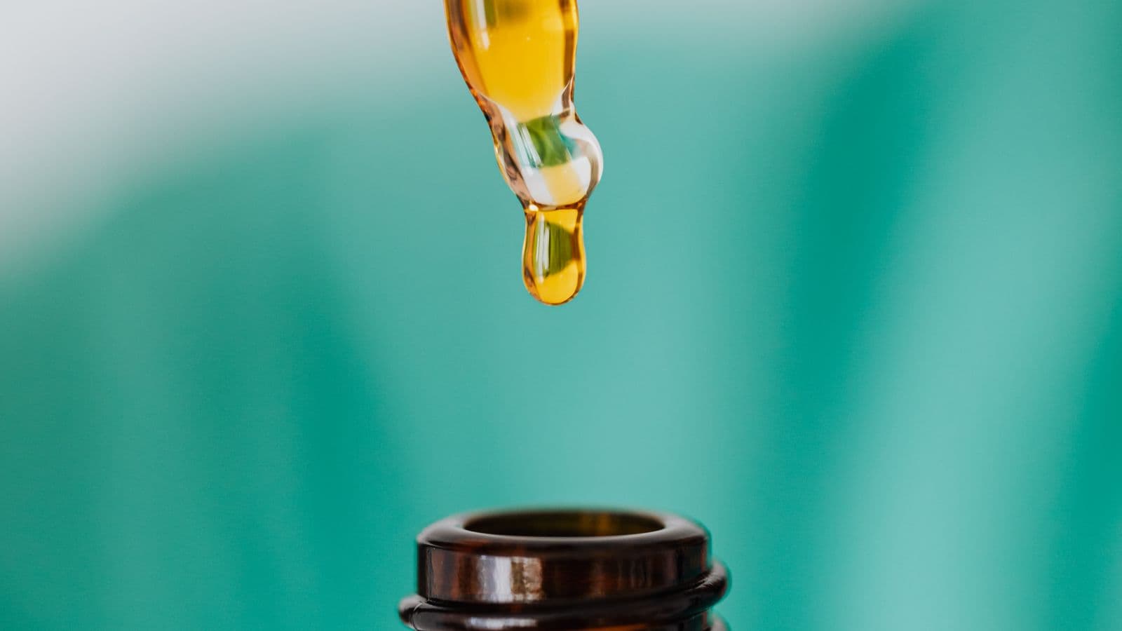 Pipeta gotejando óleo em frasco âmbar de vidro farmacêutico
