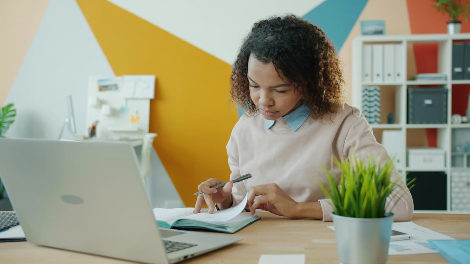 A founder focused on her laptop in a bright, colourful office