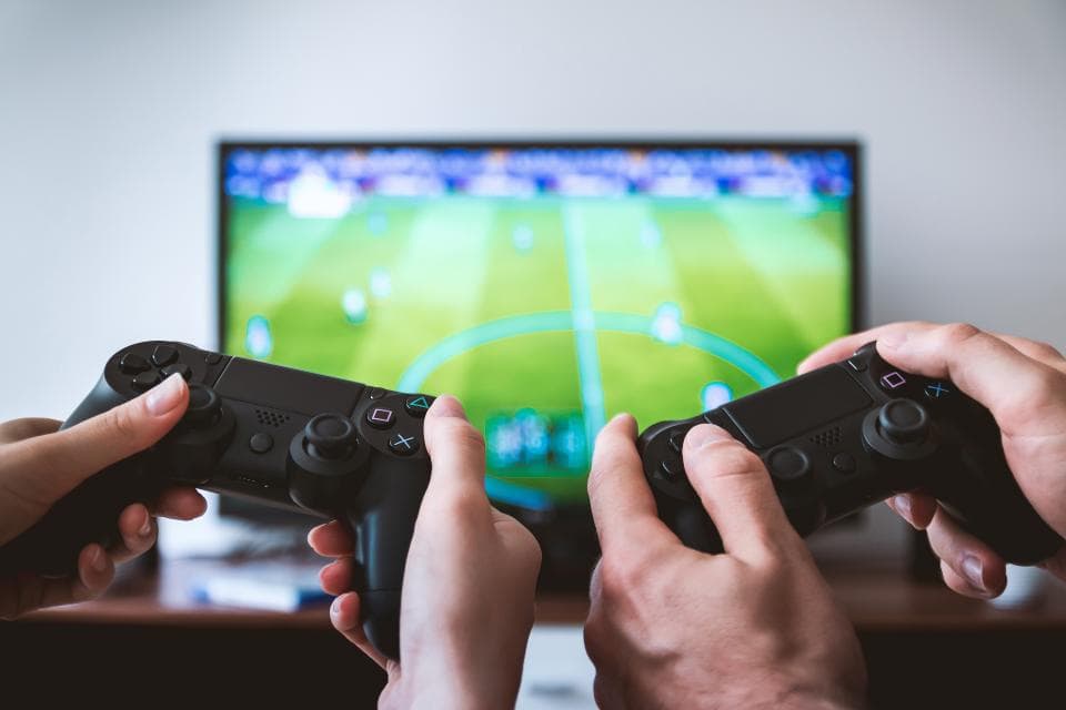 Dois jogadores com controles jogando videogame juntos